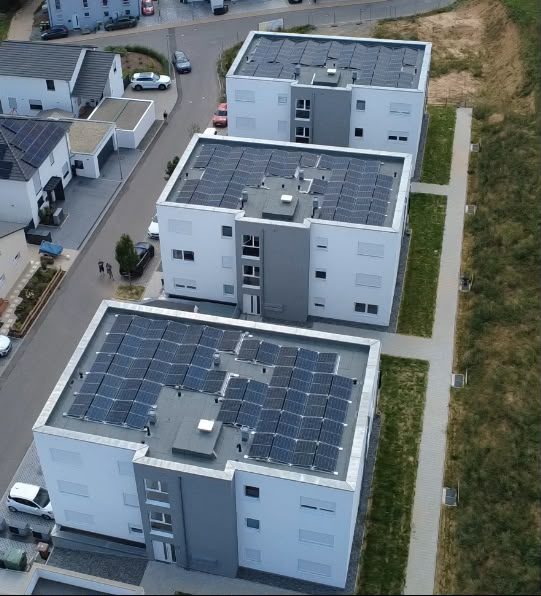 Straßenseitige Ansicht der Wohnanlage mit Tiefgaragenzufahrt